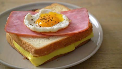 homemade-bread-toasted-cheese-topped-ham-and-fried-egg-with-pork-sausage-for-breakfast