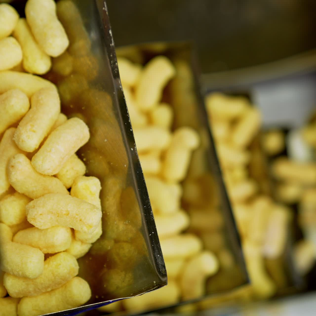 Produção de petiscos de milho crocantes. Milho puff amarelo crocante se movendo na esteira