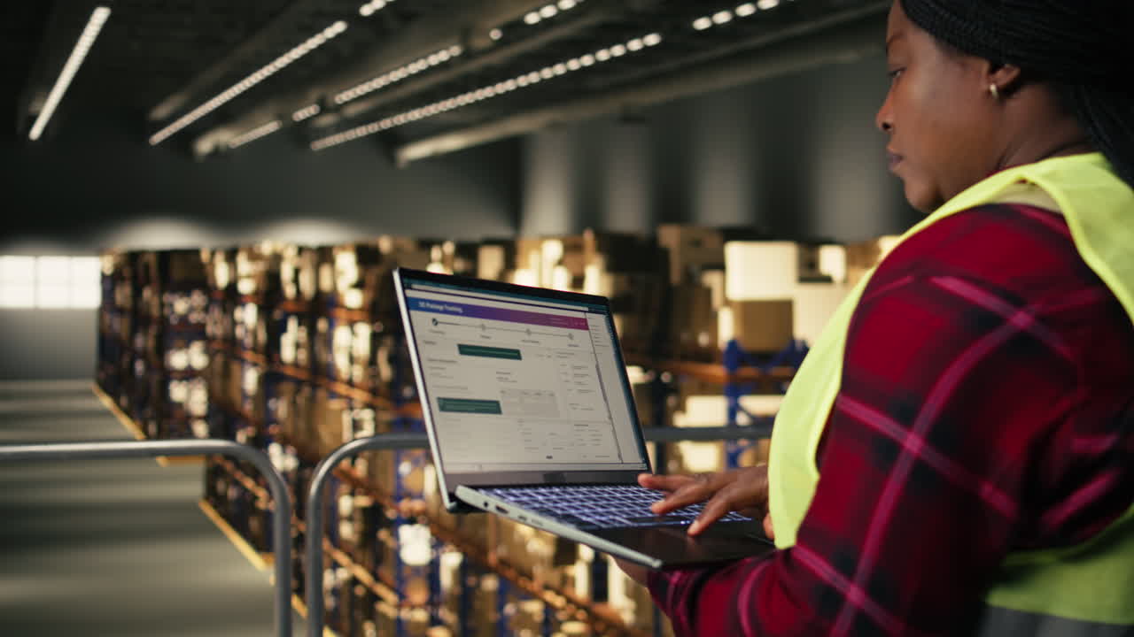 Female Logistics Manager Working on Laptop in Warehouse