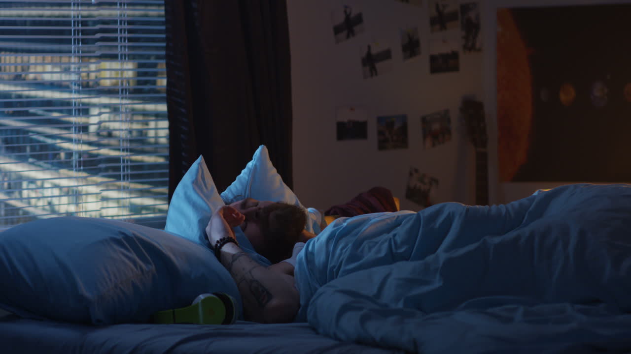 밤에 침대에서 자고 있는 남자