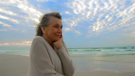 Side-view-of-active-senior-Caucasian-woman-standing-on-the-beach-4k