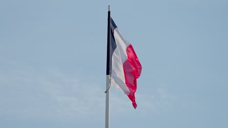 En-Cámara-Lenta,-La-Bandera-Francesa-Baila-Con-Gracia-En-El-Abrazo-Del-Viento.