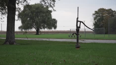old metal water pump on an overcast evening before dusk at seims park in union, il