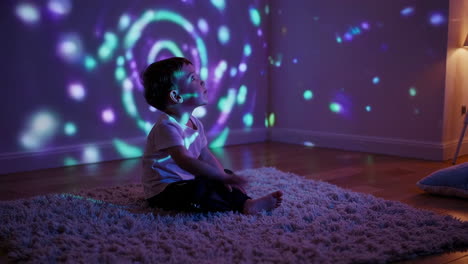 young child captivated by vibrant light show at home