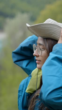 young woman in nature with hat and glasses