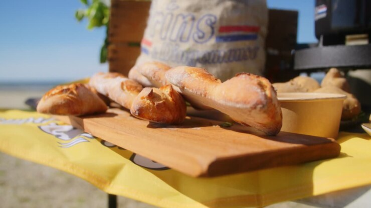 French baguette laying on a table outside on a sandy beach in the summer