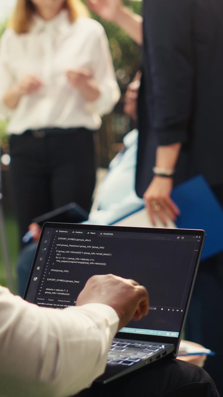 Vertical Video African american businessman coding on laptop terminal window on terrace