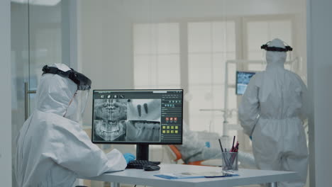 Professional-dentistry-staff-with-ppe-suit-looking-at-teeth-x-ray