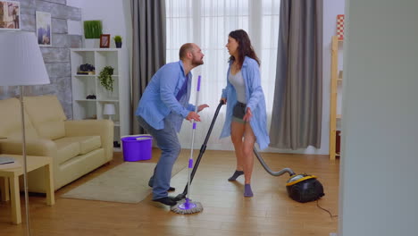 una pareja loca y divertida limpiando la casa.
