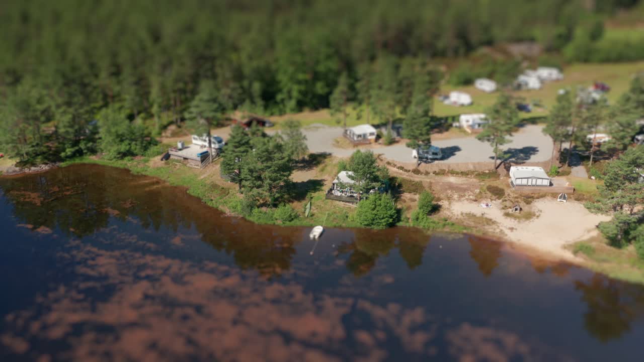 un vuelo sobre un campamento kilefjorden ubicado cerca de un bosque de coníferas en la costa de otro río