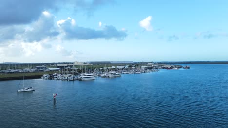 a fast panning drone view of multiple boats docked in a protected harbor located in the town of bargara bundargerg queensland australia