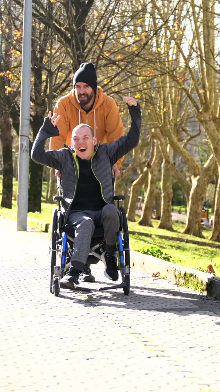 Man in wheelchair being assisted in a park