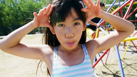 Portrait-of-schoolgirl-making-faces-in-playground