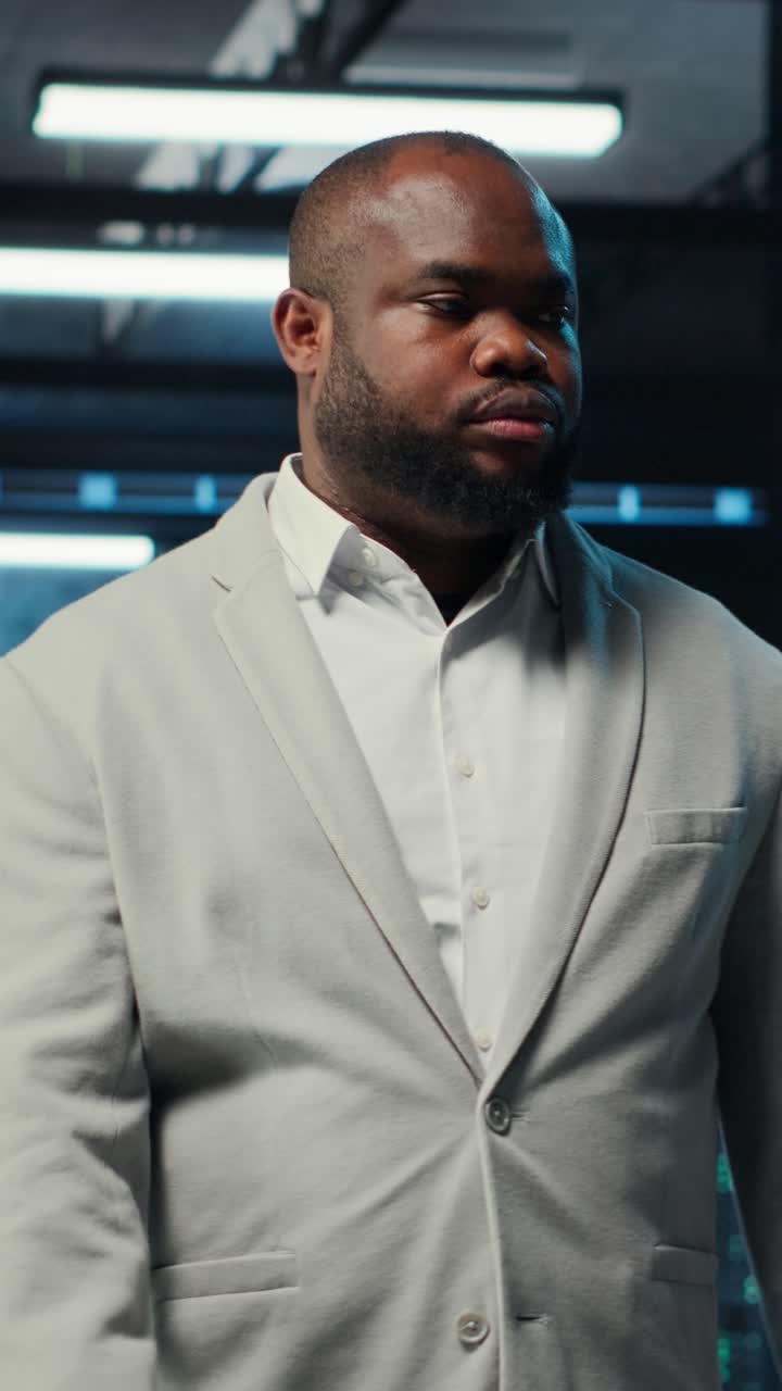 Vertical video Employee walking in data center with blinking lights on rigs