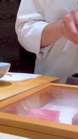 el chef maneja hábilmente el pulpo en la preparación de sushi.