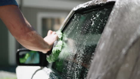 man washing car window