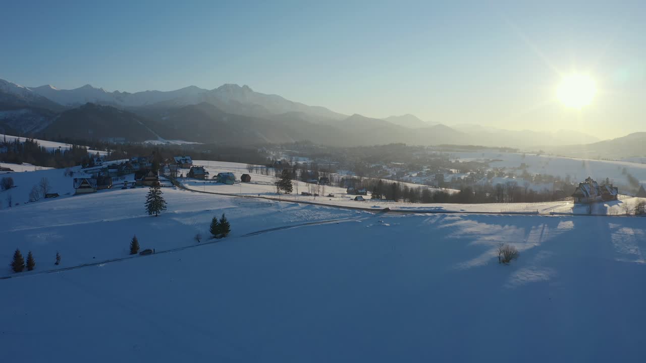 지나가는 차와 함께 조용한 마을의 겨울 태양 드론 공중 촬영