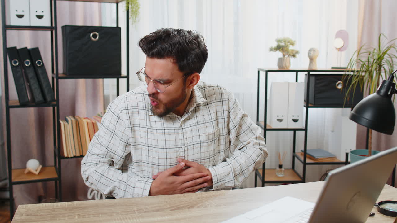 empresario indio molesto trabajador independiente tocando el estómago y experimentando incomodidad dolor agudo