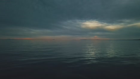 aerial view of calm waves at a dark cloudy evening