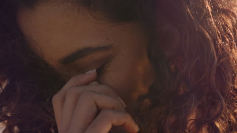 retrato en primer plano de una mujer hermosa y feliz disfrutando de la libertad explorando la espiritualidad sintiendo esperanza en la pacífica orilla del mar al atardecer con el pelo soplado por el viento