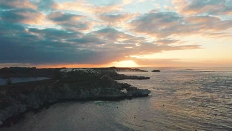 Sonnenuntergang-Auf-Felsen,-Drohnenaufnahme,-Die-Rückwärts-Fliegt---Rottnest-Island,-Westaustralien