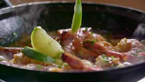 lime wedges dropped onto shrimp in skillet