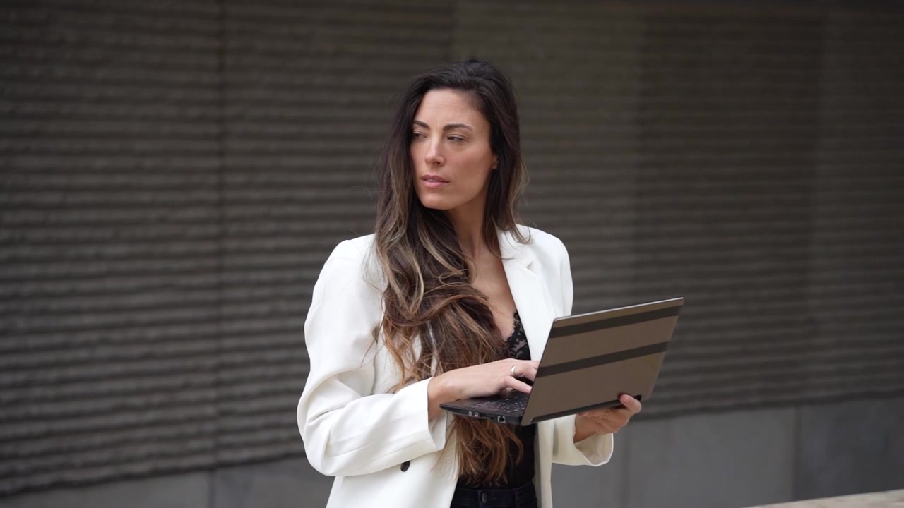 Una mujer profesional interactuando con su tableta al aire libre mientras está inmersa en sus tareas laborales.