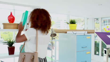 Female-executive-keeping-file-in-shelf