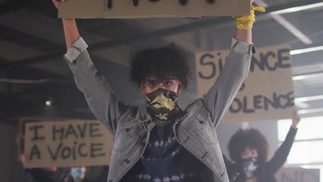 Diverse-group-of-people-wearing-face-masks-holding-protest-signs