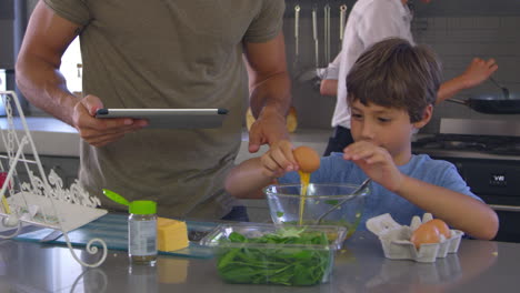 familia en la cocina siguiendo la receta en una tableta digital juntos