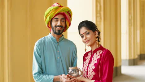 portrait of an indian couple holding a candle lantern in their hands