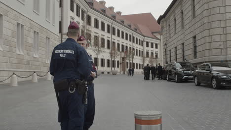 two hungarian police officers and security agents outside the former honved high command building for a joint press conference with victor orban and marjan sarec.