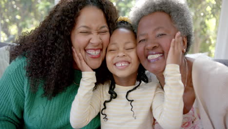 Portrait-of-african-american-mother,-daughter-and-grandmother-smiling-in-sunny-room,-slow-motion