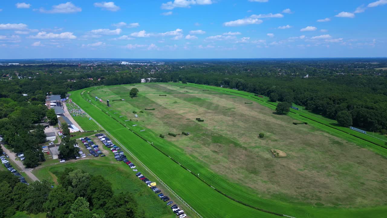 horse racing track with spectators enjoying the competition on a sunny summer day. Majestic aerial view flight fly reverse drone