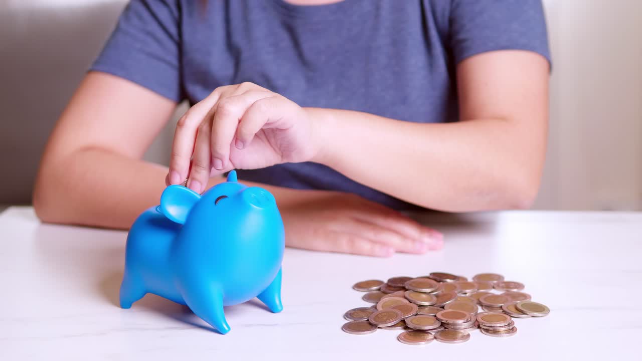 Woman putting coin in piggy bank, saving money concept