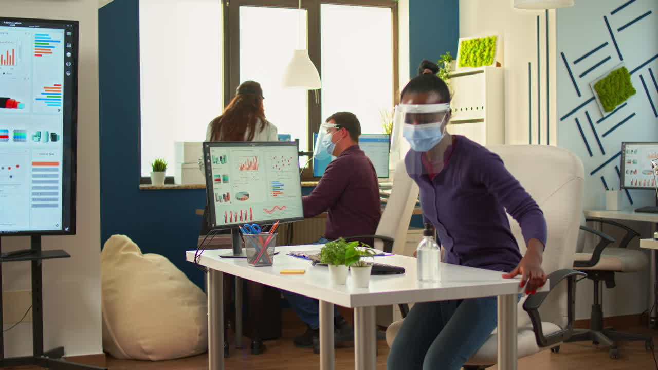empleado negro limpiando las manos con gel desinfectante antes de trabajar