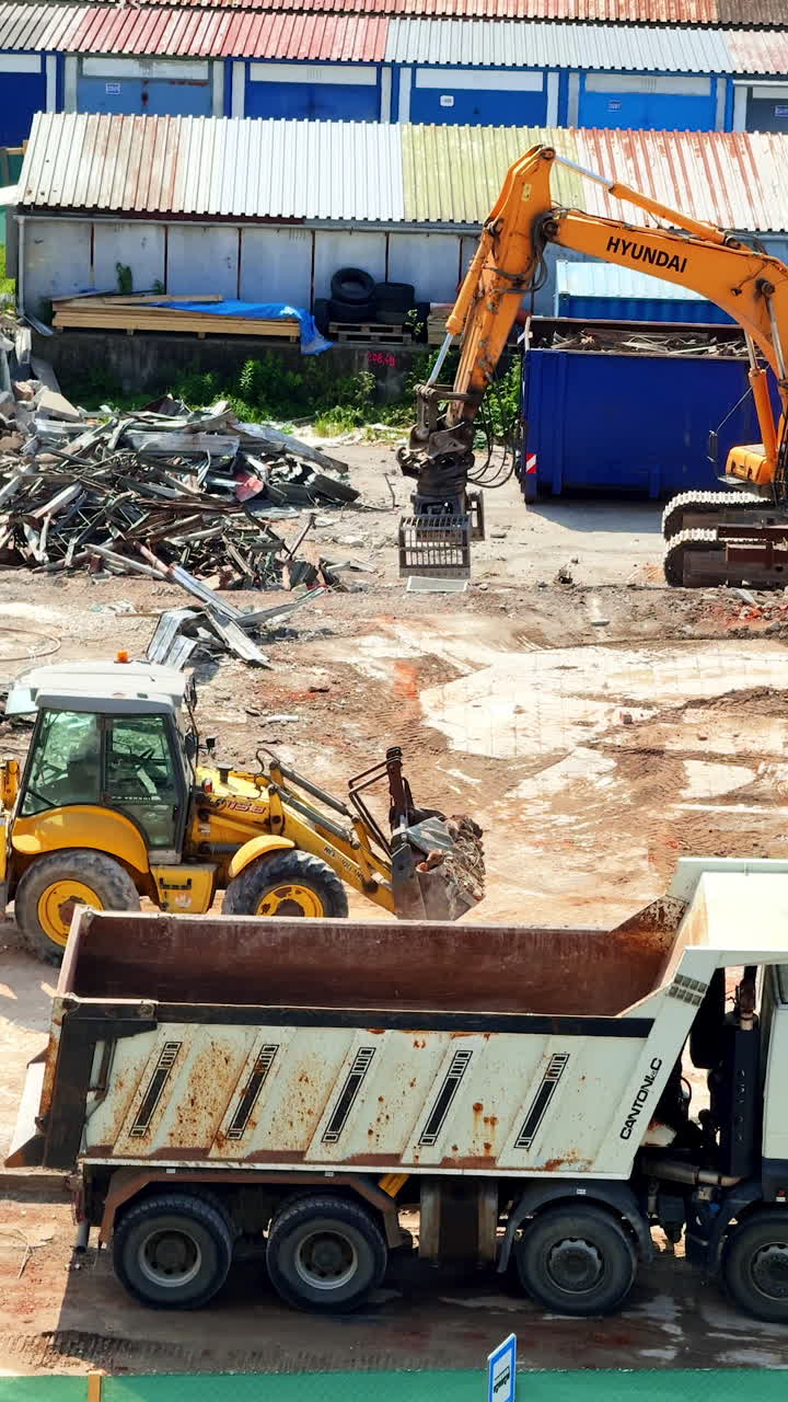 Heavy machinery at a site. Heavy machinery is working at the construction site, clearing debris and prepping the area for development