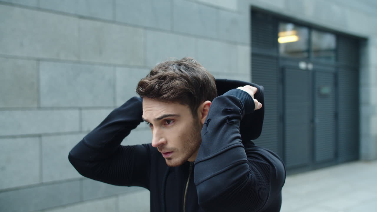 집중된 남자가 슬로우 모션으로 거리를  ⁇ 고 있다. 스포츠웨어를 입은 섹시한 남자의 초상화.