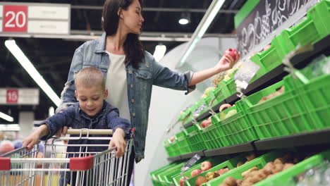 mother and child shopping for fruits at supermarket