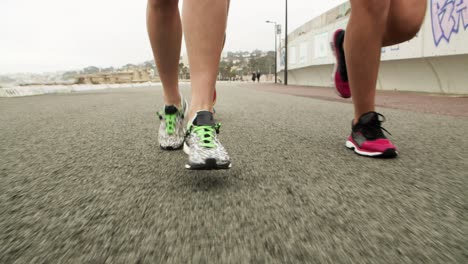 ankles and feet of athletes jogging along road