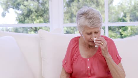 Senior-woman-sneezing-on-the-sofa