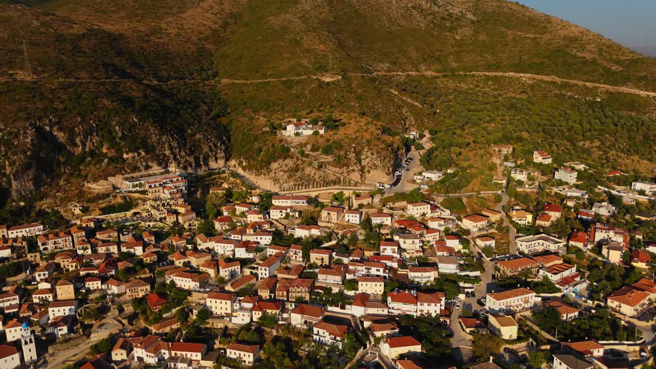 Dhermi, a historic albanian town, surrounded by rugged mountains at golden hour, aerial view