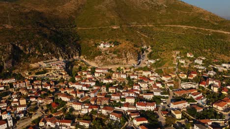 dhermi, a historic albanian town, surrounded by rugged mountains at golden hour, aerial view