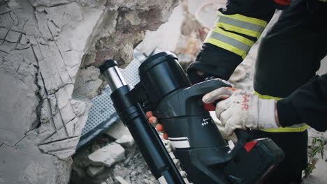 firefighter using hydraulic ram to rescue victims from a collapsed building