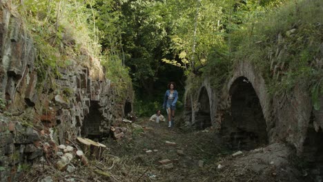 mujeres jóvenes explorando un túnel abandonado en un bosque