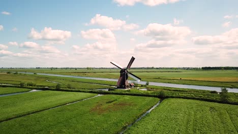 traditional windmill in dutch landscape aerial shot flying towards the mill