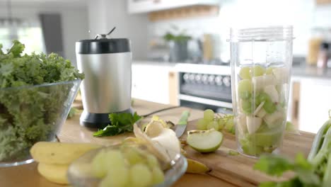 vegetables and fruits with kitchen equipment on countertop in kitchen at home, slow motion