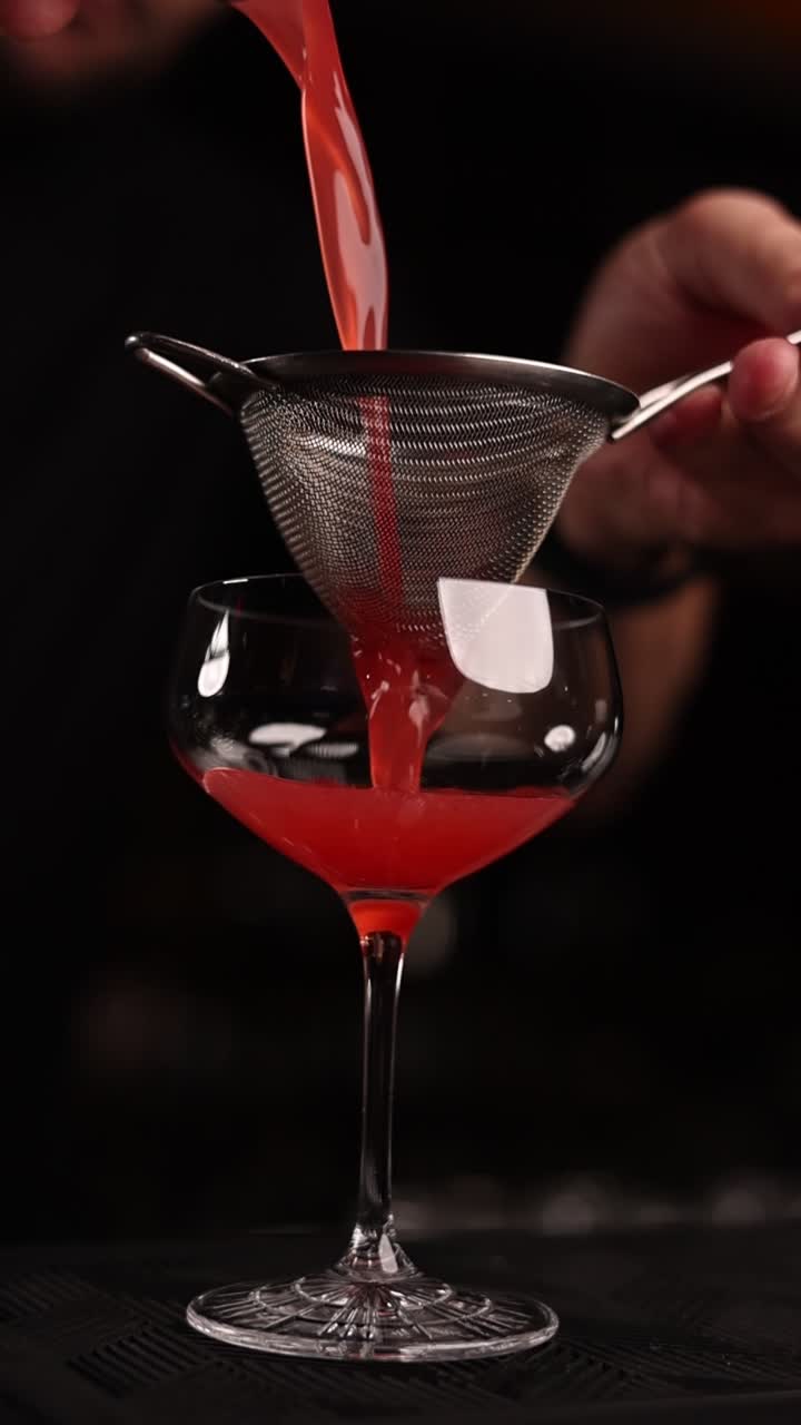 Il barista che versa un cocktail rosso