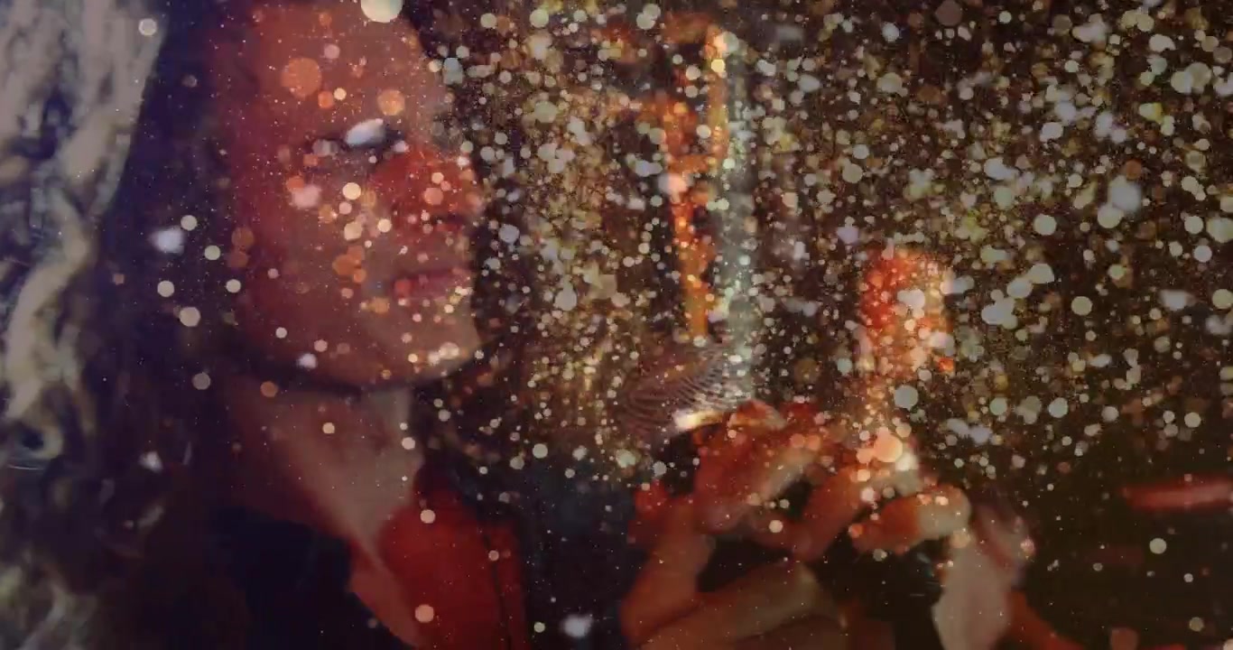Singer launching note, moving hands on mic, particles cascading around face and mic for music show
