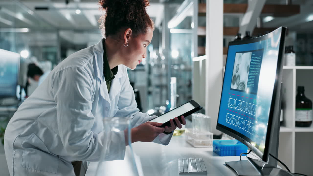 Scientist working in a laboratory with computer and tablet